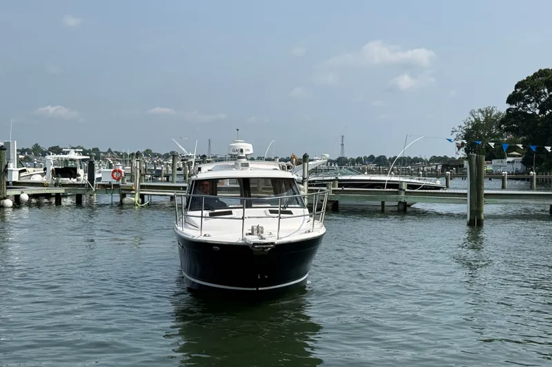 Slide: The Image of 2024 Cutwater C-248 Coupe boat docked in a marina under a clear sky. - 10