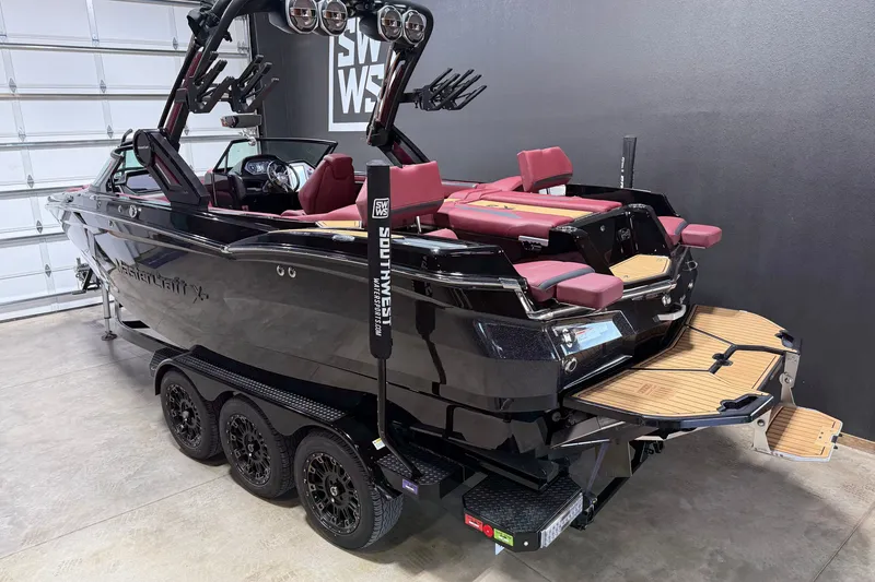 Slide: The Image of 2023 MasterCraft XStar S boat with sleek black design and red seating in a garage. - 23