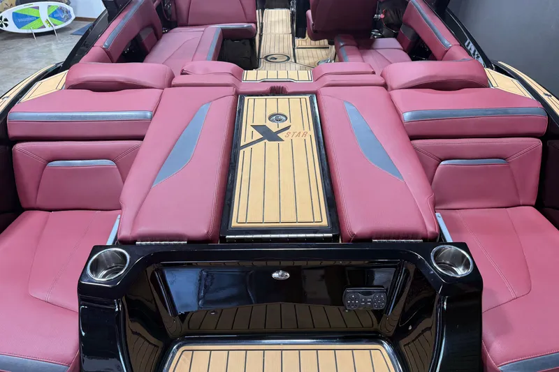 Slide: The Image of 2023 MasterCraft XStar S boat interior with red seating and wood accents. - 17