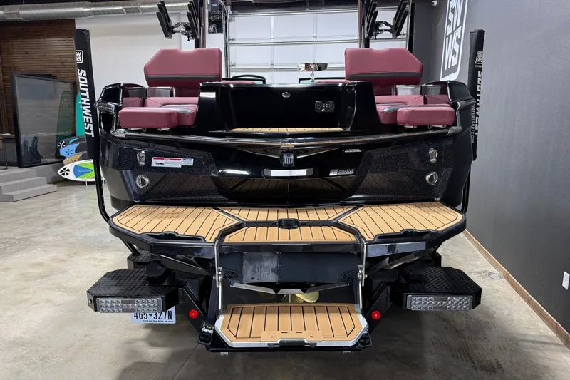 Slide: The Image of 2023 MasterCraft XStar S boat with teak deck and maroon seating in showroom. - 25