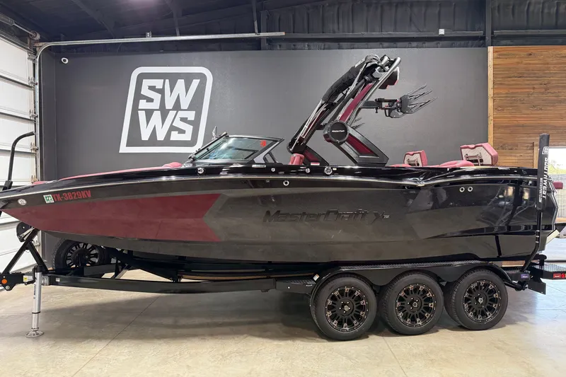 The Image of 2023 MasterCraft XStar S boat on trailer in showroom setting. - 0