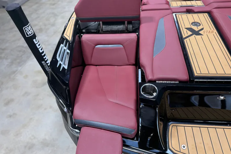 Slide: The Image of 2023 MasterCraft XStar S boat interior with red seating and teak accents. - 19