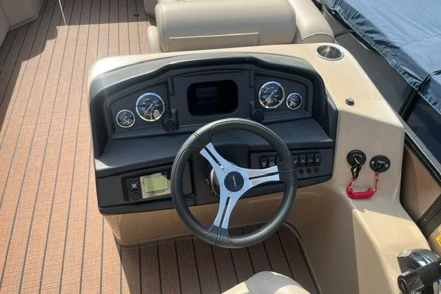 Slide: The Image of 2023 Bentley Pontoons Legacy 243 Cruise dashboard with steering wheel and gauges. - 10