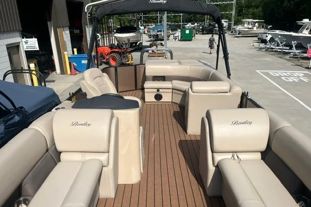 Slide: The Image of 2023 Bentley Pontoons Legacy 243 Cruise with spacious seating and elegant design at a marina. - 7