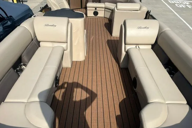 Slide: The Image of 2023 Bentley Pontoons Legacy 243 Cruise interior with beige seating and wood-style flooring. - 6