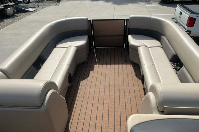 Slide: The Image of 2023 Bentley Pontoons Legacy 243 Cruise interior with beige seating and wood-style flooring. - 11