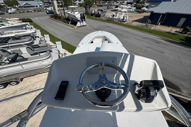 Slide: The Image of 2020 Front Runner 39 Center Console helm with steering wheel and controls, marina background. - 26