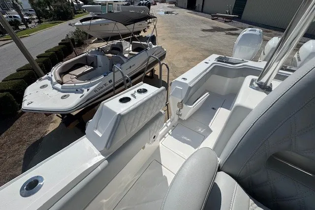 Slide: The Image of 2020 Front Runner 39 Center Console boat with sleek seating and cup holders, docked beside another vessel. - 19