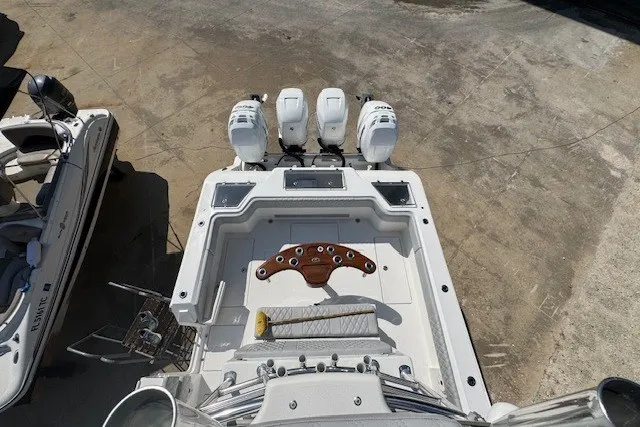 Slide: The Image of 2020 Front Runner 39 Center Console boat with triple outboard engines, docked on concrete. - 28