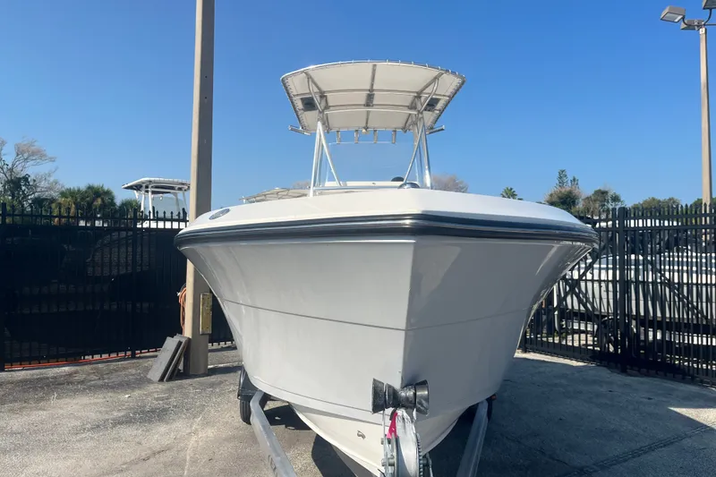 Slide: The Image of 2024 Cobia 237 Center Console boat on trailer, parked outdoors. - 3