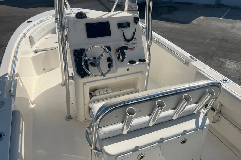 Slide: The Image of 2024 Cobia 237 Center Console boat interior with steering wheel and rod holders. - 12