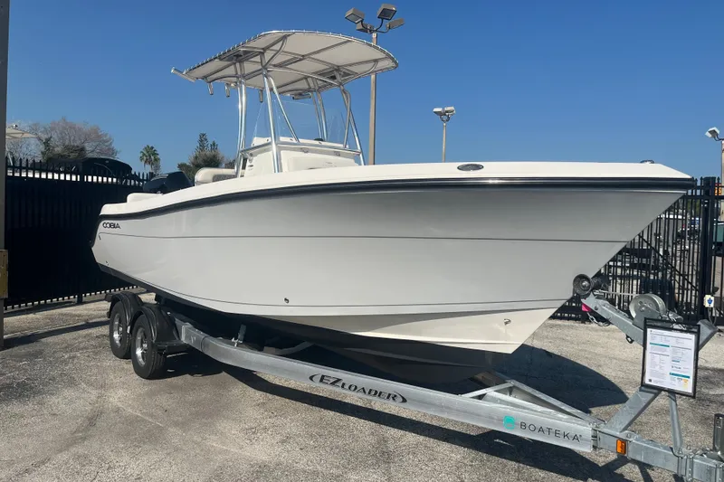 Slide: The Image of 2024 Cobia 237 Center Console boat on trailer, displayed outdoors. - 2