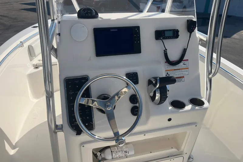Slide: The Image of 2024 Cobia 237 Center Console boat dashboard with steering wheel and navigation controls. - 11