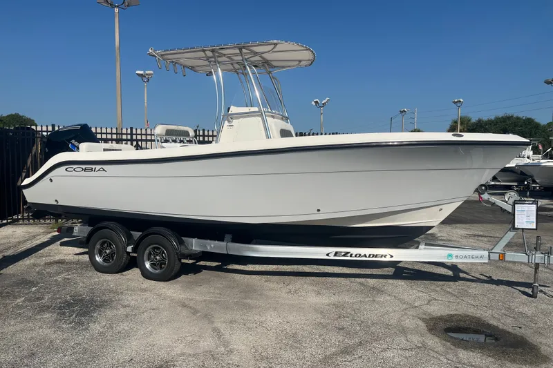The Image of 2024 Cobia 237 Center Console boat on trailer, displayed outdoors. - 1
