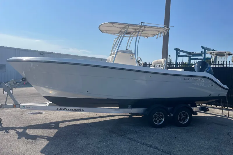Slide: The Image of 2024 Cobia 237 Center Console boat on trailer in sunny outdoor setting. - 5