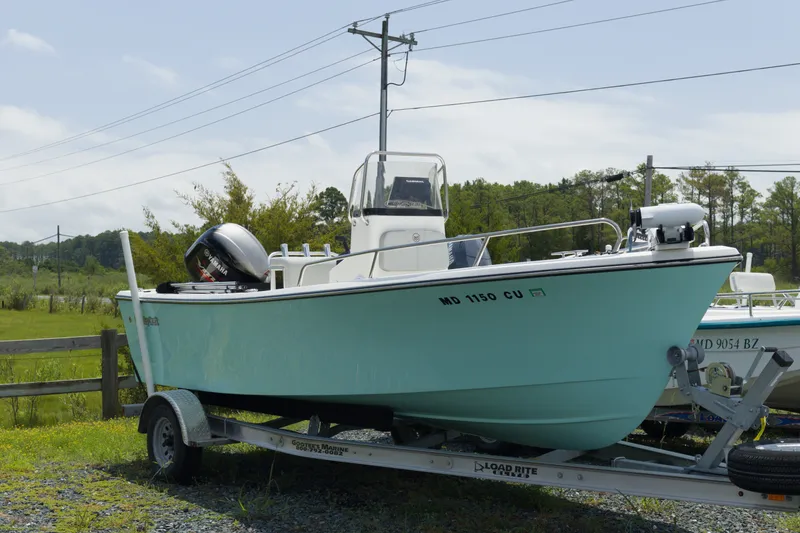 The Image of 2023 May-Craft 1900CC boat on trailer, light blue hull, parked outdoors. - 1