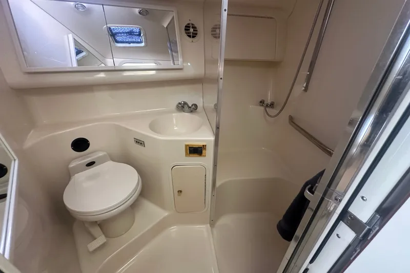 Slide: The Image of 1999 Sea Ray Sundancer 370 bathroom with toilet, sink, and shower in compact marine design. - 23