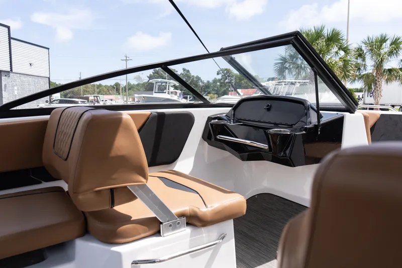 Slide: The Image of 2023 Glastron GX 210 boat interior with tan seating and sleek dashboard design. - 13