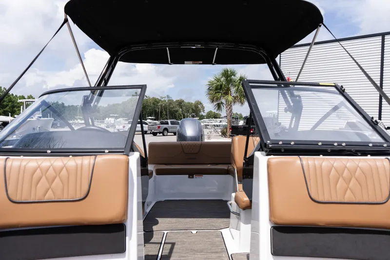 Slide: The Image of 2023 Glastron GX 210 boat interior with tan seats and open windshield. - 9