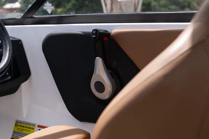 Slide: The Image of Interior of 2023 Glastron GX 210 boat, featuring sleek controls and tan seating. - 12