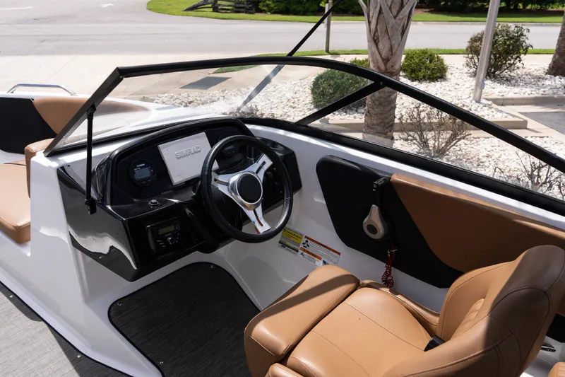 Slide: The Image of 2023 Glastron GX 210 boat interior with modern dashboard and tan seating. - 10