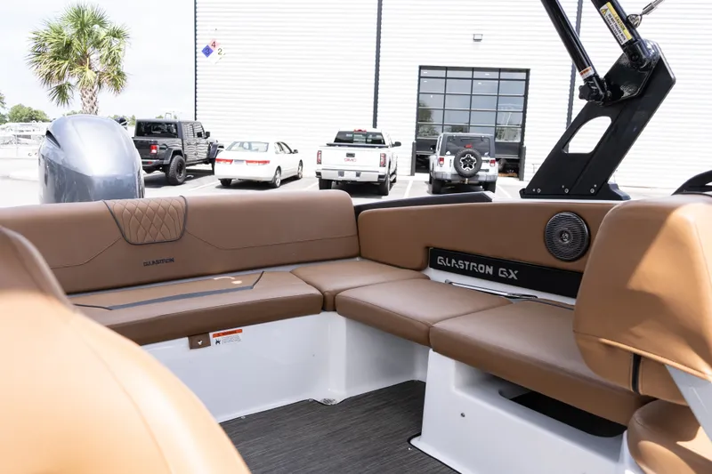 Slide: The Image of 2023 Glastron GX 210 boat interior with brown seating and modern design. - 14