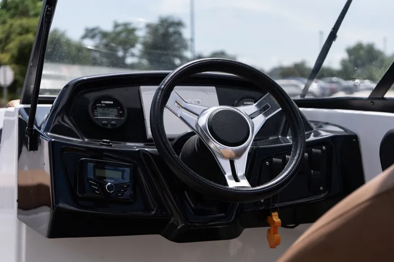 Slide: The Image of 2023 Glastron GX 210 boat dashboard with steering wheel and Yamaha controls. - 11