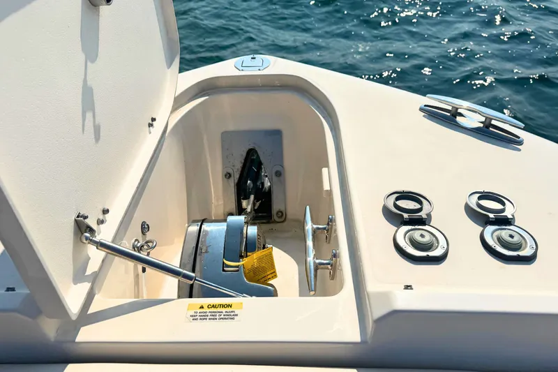 Slide: The Image of 2023 Grady-White Freedom 285 boat anchor compartment with open hatch, on calm water. - 45