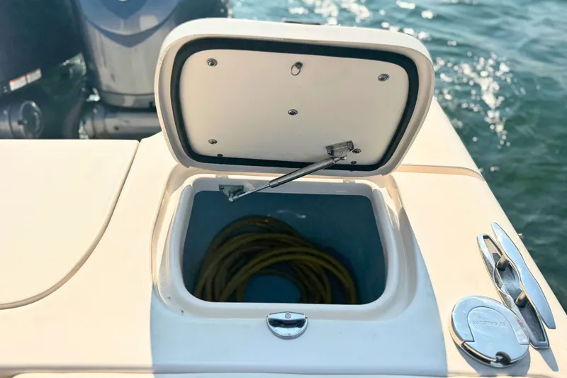Slide: The Image of Open storage compartment on 2023 Grady-White Freedom 285 boat, with coiled rope inside. - 15