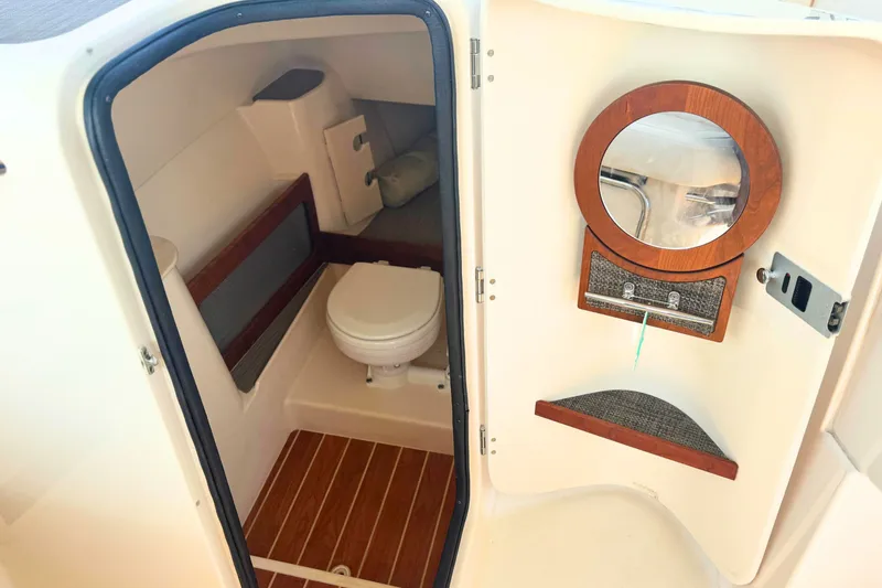 Slide: The Image of 2023 Grady-White Freedom 285 boat interior with toilet and wooden accents. - 34