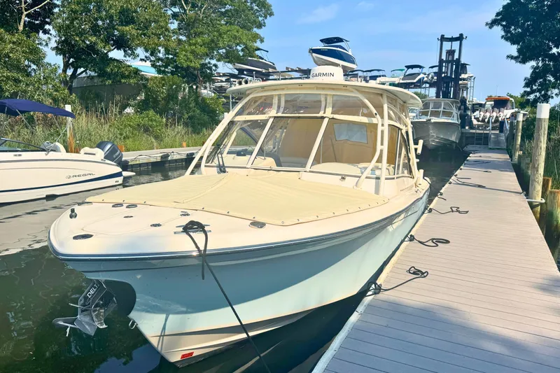 Slide: The Image of 2023 Grady-White Freedom 285 boat docked at marina with trees in background. - 10