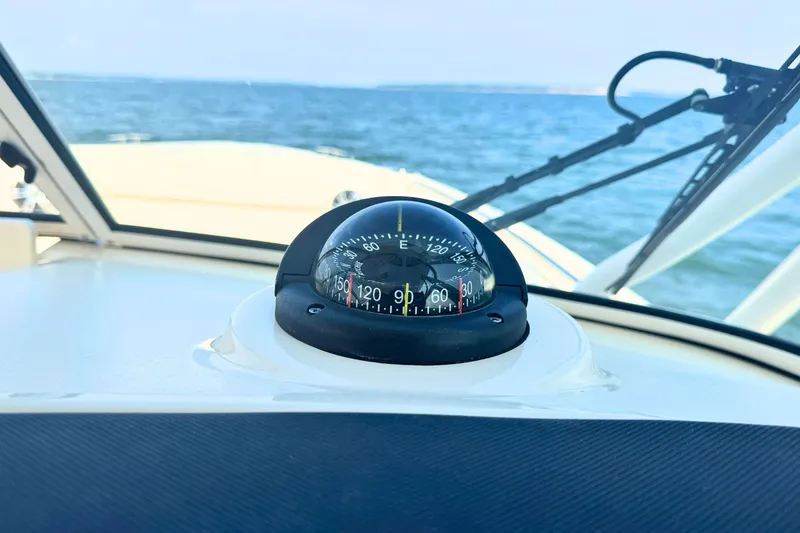 Slide: The Image of Compass on 2023 Grady-White Freedom 285 boat dashboard, overlooking the ocean. - 41