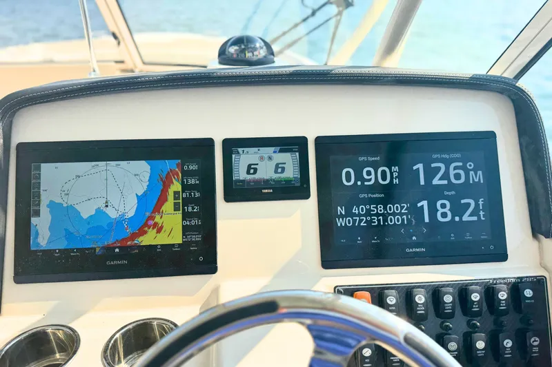 Slide: The Image of Dashboard of 2023 Grady-White Freedom 285 with Garmin navigation displays and controls. - 40