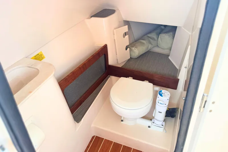 Slide: The Image of 2023 Grady-White Freedom 285 boat interior with compact marine toilet and storage area. - 35