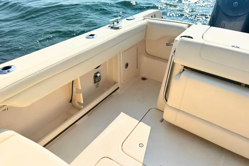 Slide: The Image of 2023 Grady-White Freedom 285 boat interior with seating and storage, on calm water. - 16