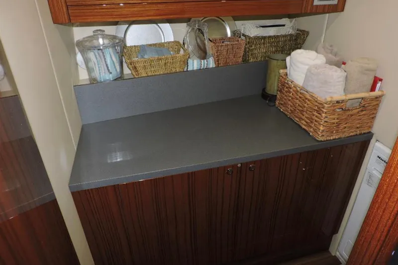 Slide: The Image of 2016 Maritimo M51 yacht interior with countertop, wicker baskets, and towels. - 30