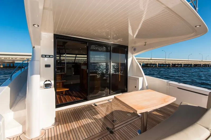 Slide: The Image of 2016 Maritimo M51 yacht deck with table, overlooking water and bridge. - 14