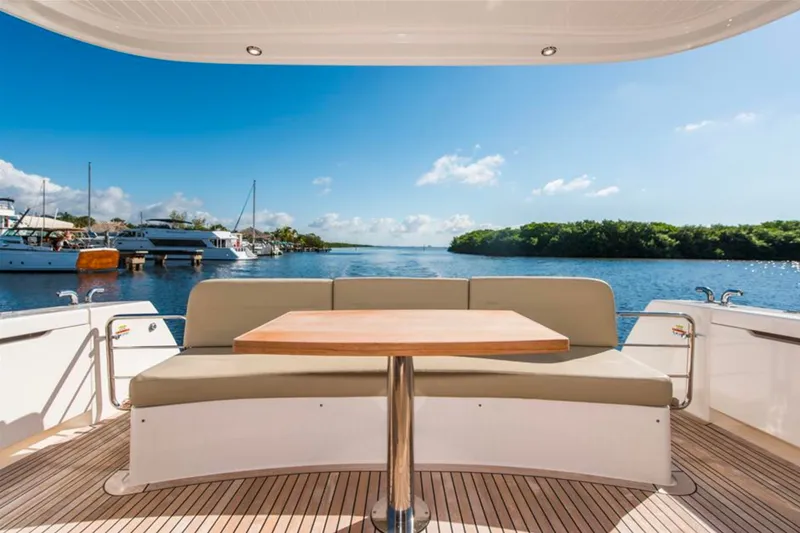 Slide: The Image of Luxury Maritimo M51 yacht deck with seating, table, and scenic waterfront view. - 18