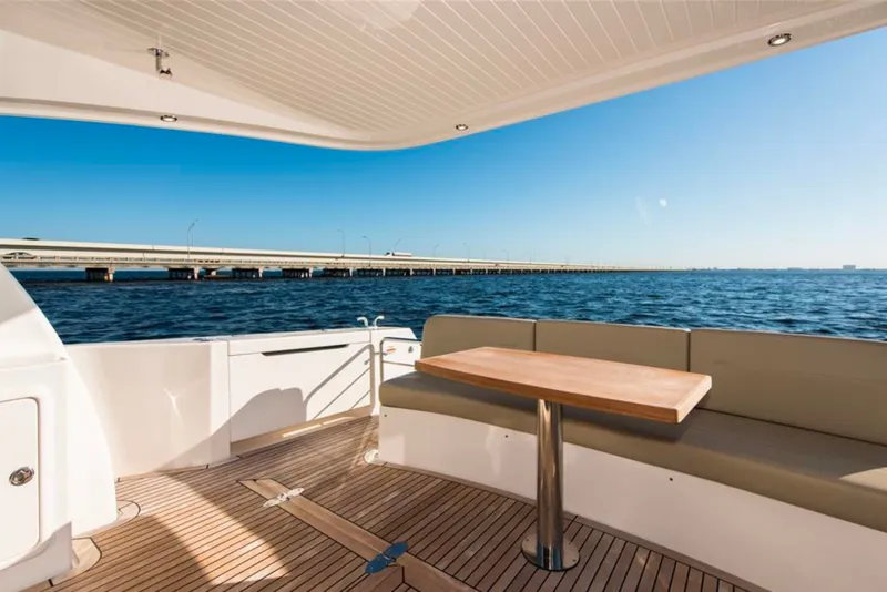 Slide: The Image of Luxury Maritimo M51 yacht deck with ocean view, featuring elegant seating and wooden table, 2016 model. - 19