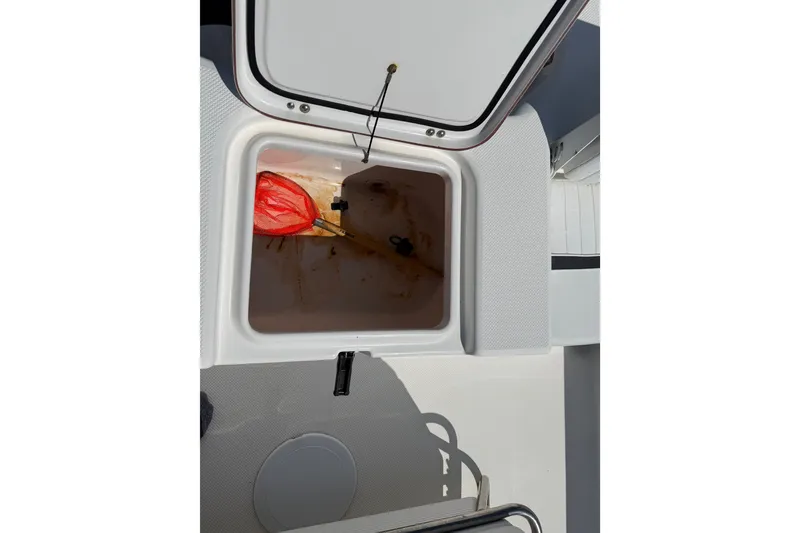 Slide: The Image of Open storage compartment on 2012 Sea Fox 200XT boat with a red net inside. - 29