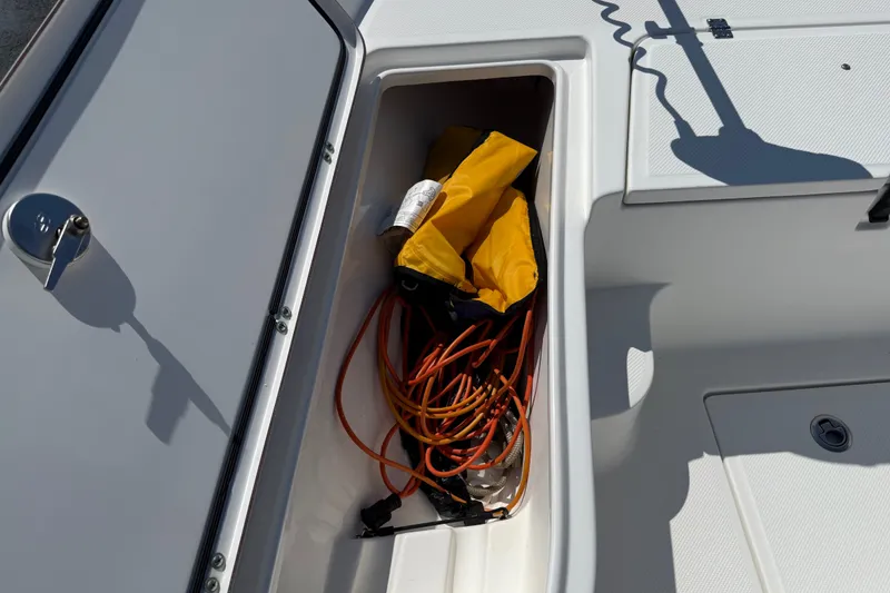 Slide: The Image of Storage compartment on a 2012 Sea Fox 200XT boat with safety gear and cables. - 18