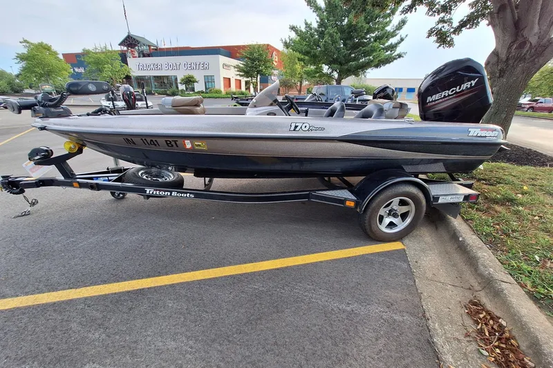 The Image of 2000 Triton Tr-17 boat on trailer, parked near Tracker Boat Center. - 1