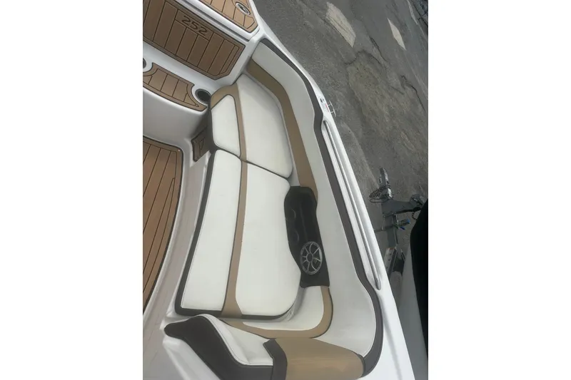 Slide: The Image of 2023 Yamaha Boats 252S interior seating with tan and white upholstery. - 25