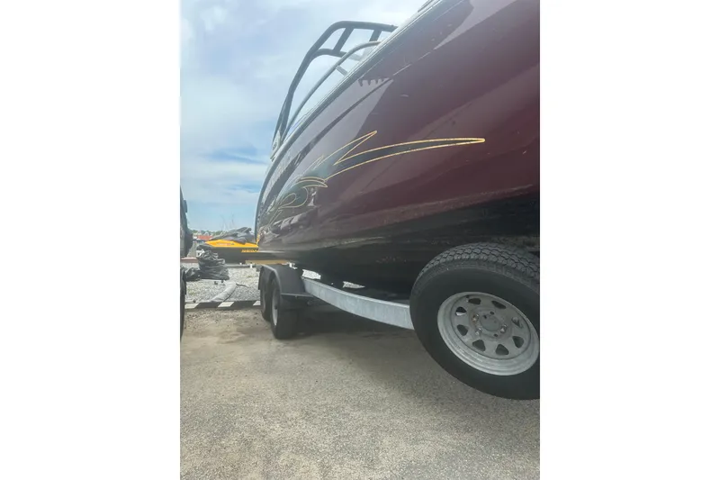 Slide: The Image of 2023 Yamaha Boats 252S on trailer, side view with decorative graphics. - 13