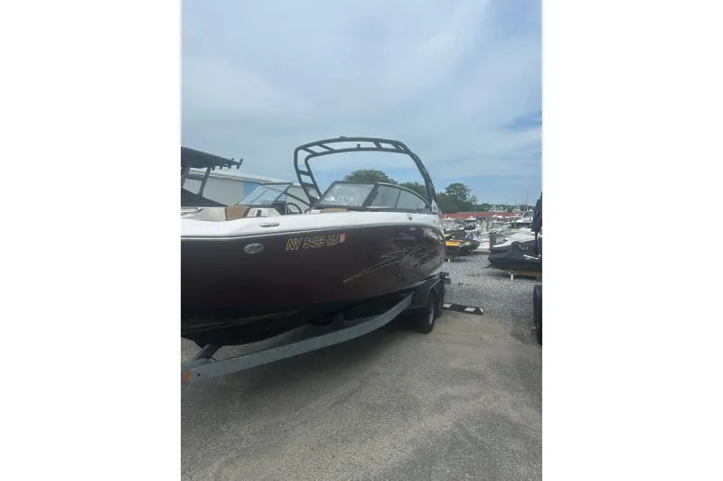 Slide: The Image of 2023 Yamaha Boats 252S on trailer, parked outdoors at a marina. - 2