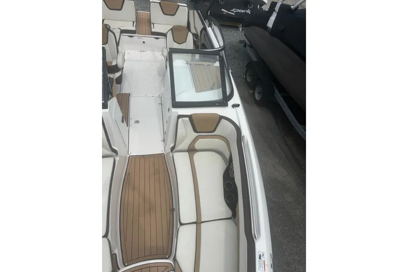 Slide: The Image of 2023 Yamaha Boats 252S interior with tan and white seating, wood-style flooring. - 21