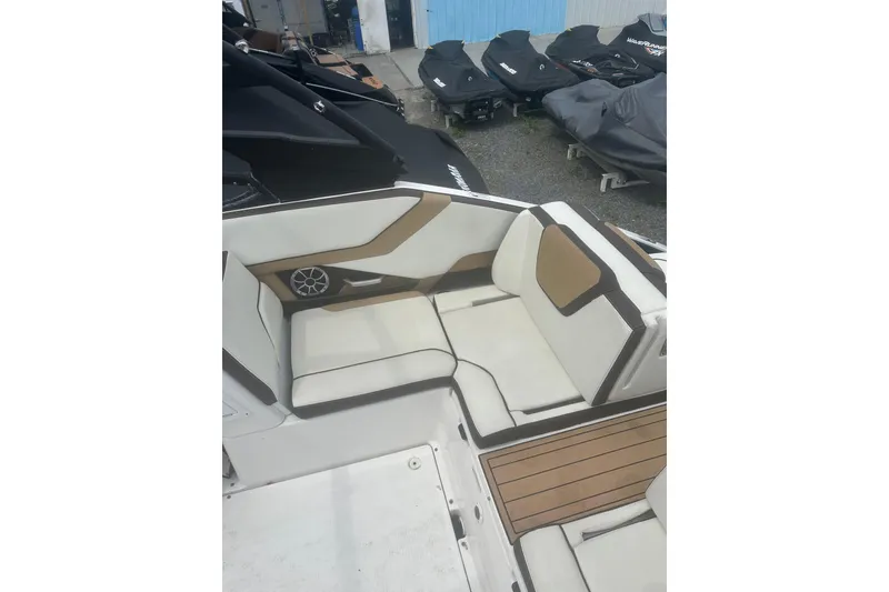 Slide: The Image of 2023 Yamaha Boats 252S interior with white and tan seating, featuring a speaker. - 30