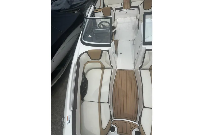 Slide: The Image of 2023 Yamaha Boats 252S interior with sleek seating and wood-style flooring. - 20