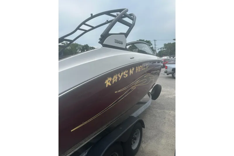 Slide: The Image of 2023 Yamaha Boats 252S with custom graphics on trailer. - 11