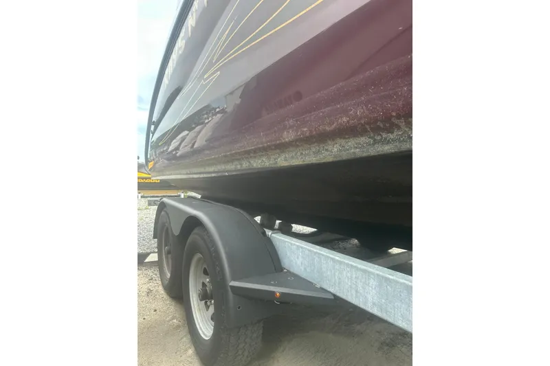 Slide: The Image of 2023 Yamaha Boats 252S on trailer, close-up of hull and wheels. - 17